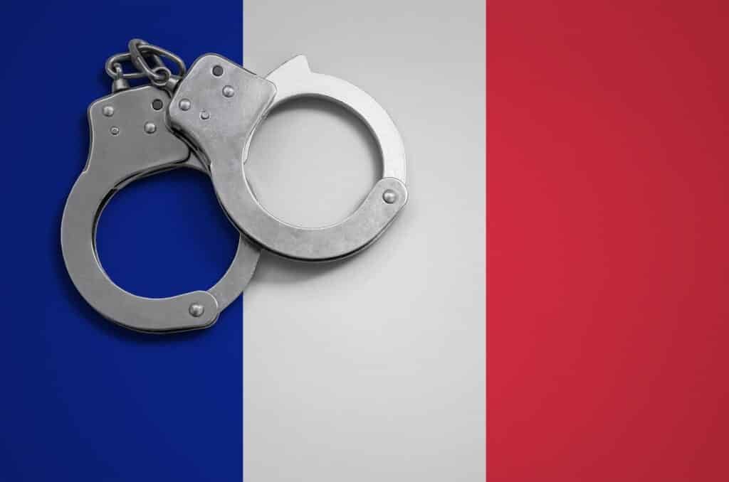 France flag and police handcuffs. The concept of crime and offenses in the country.